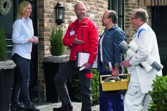 Eine Person in toom Arbeitskleidung macht mehrere Personen miteinander bekannt.